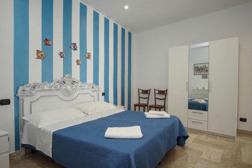 モーラ・ディ・バーリにあるB&B Le Terrazzeのベッドルーム1室(青と白のストライプのベッド1台付)