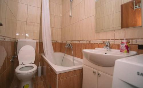 a bathroom with a toilet and a sink and a tub at Apartman Mila in Kaštela