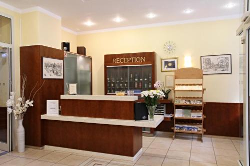 a hair salon with a reception counter and flowers at Hotel La Passionaria in Mariánské Lázně
