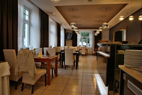 a dining room with tables and white chairs at Hotel La Passionaria in Mariánské Lázně