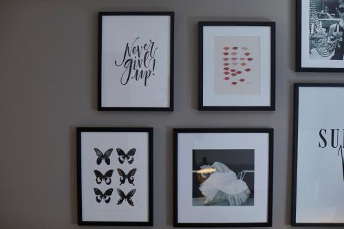 a group of framed pictures on a wall at Hotel Metropol by Maier Privathotels in Munich