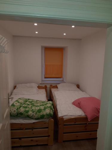 Dos camas individuales en una habitación con ventana. en Ferienwohnung Castelnau, en Trier