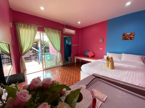 a room with a bed and a table with flowers at Phuttharaksa Resort in Ko Larn