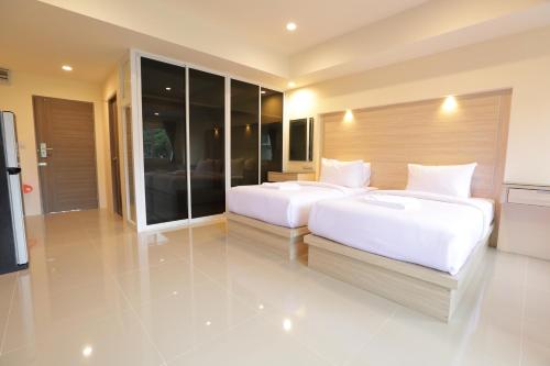two beds in a large room with glass walls at Lampang Residence in Lampang