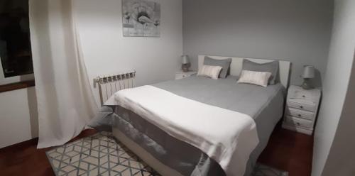 - une chambre blanche avec un grand lit et des draps blancs dans l'établissement Lourenço House, à Póvoa de Varzim