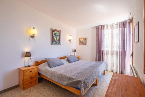 a bedroom with a bed with two blue pillows at Villa Bouganvilla in Tossa de Mar