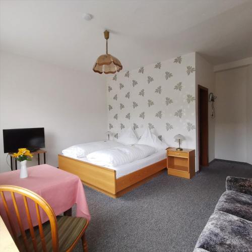 a bedroom with a bed and a table and a couch at Hotel Restaurant LAHNHOF in Dausenau