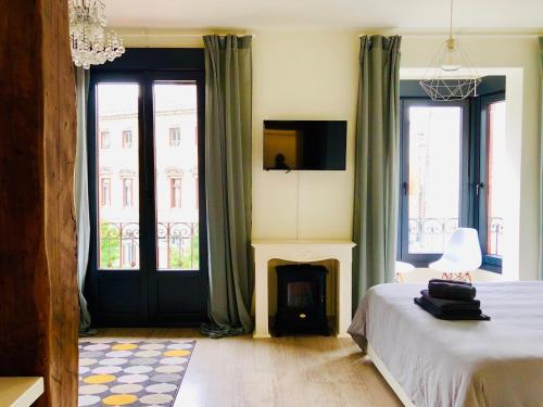 a bedroom with a bed and a fireplace and windows at Espectacular suite con vistas a la ría in Bilbao