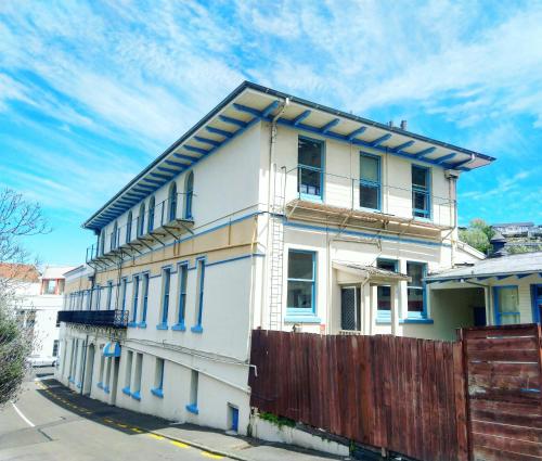 een wit huis met blauwe rand op een straat bij Toad Hall Accommodation in Napier