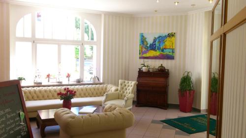 a living room with a couch and a table at Parkhotel Meerane in Meerane