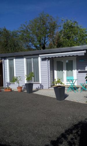 a small house with potted plants in front of it at AGREABLE PETIT CHALET in Camarsac