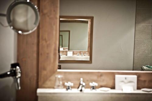 a bathroom with a sink and a mirror at Hôtel Les Barmes De l'Ours in Val-d'Isère