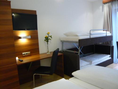 a room with a desk and a bed and a bunk bed at Hotel Das Essigmanngut in Anif