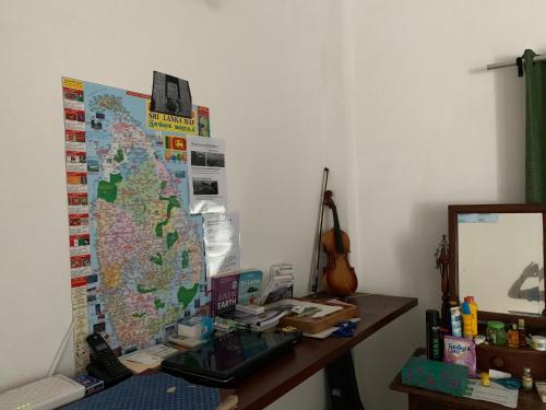 a desk with a laptop and a map on the wall at Sea Sands Beach Hostel in Negombo