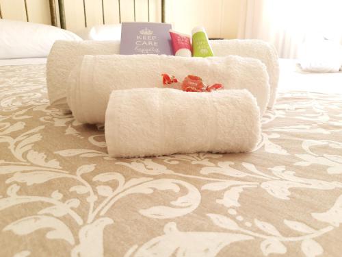 a pile of white towels sitting on a bed at B&B Murgantia in Morcone