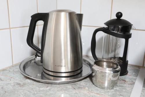 a tea kettle and a coffee pot on a counter at Caesar's Self-catering Open Plan Suite in Somerset West