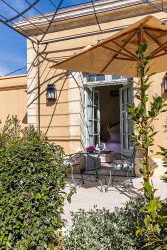 a patio with a table and chairs under an umbrella at Villa Saint-Ange in Aix-en-Provence