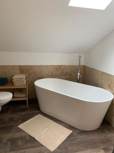 a white bath tub in a bathroom with a toilet at Ferienwohnungen Schweizerhaus in Dresden