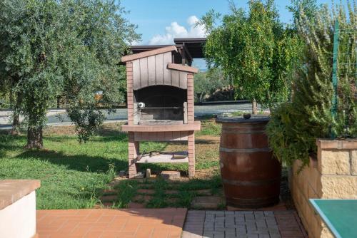 a bird house in a yard with a barrel at Poggio Picchio in Bibbona