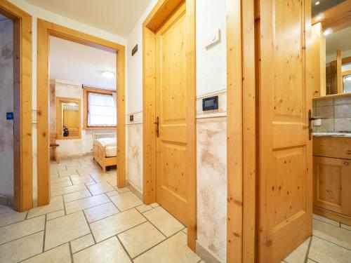 a hallway with wooden doors and a tile floor at Baita Stebline - AlpineEscape in Livigno
