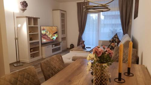 een woonkamer met een tafel en een tv bij Ferienwohnung Univers 2 in Bad Harzburg