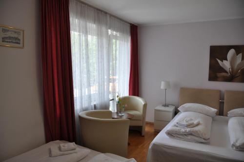 a hotel room with two beds and a window at Hotel-Pension Asta in Munich