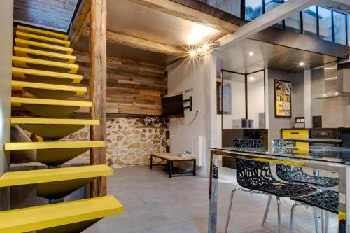 une salle à manger avec un escalier et des chaises jaunes dans l'établissement Annecy Clara's Apartment, à Annecy