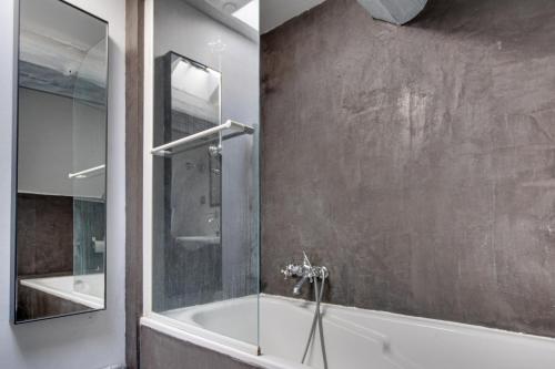 uma casa de banho com uma banheira e um chuveiro em vidro. em Annecy Clara's Apartment em Annecy