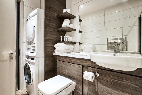 a bathroom with a sink and a toilet and a mirror at Citadines City Centre Liverpool in Liverpool