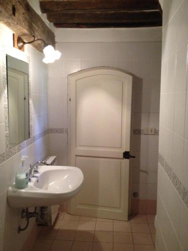 a white bathroom with a sink and a mirror at Fattoria Di Cavaglioni in San Rocco a Pilli