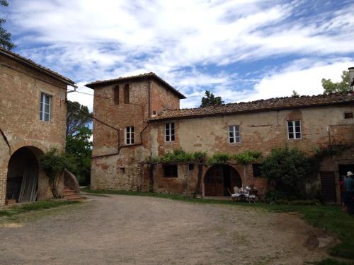 an old stone building with two people sitting in a courtyard at Fattoria Di Cavaglioni in San Rocco a Pilli