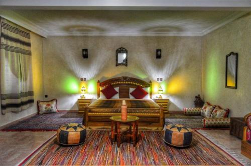 a bedroom with a large bed and a couch at Riad les jardins Mabrouk in Taroudant