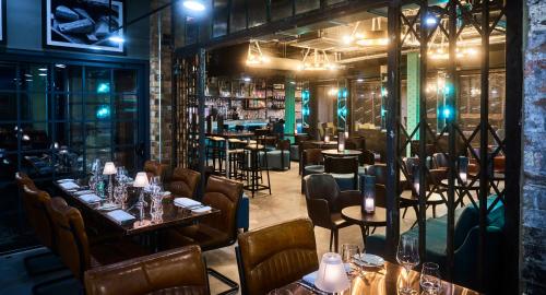 ein Restaurant mit Tischen und Stühlen und eine Bar in der Unterkunft New Road Hotel in London