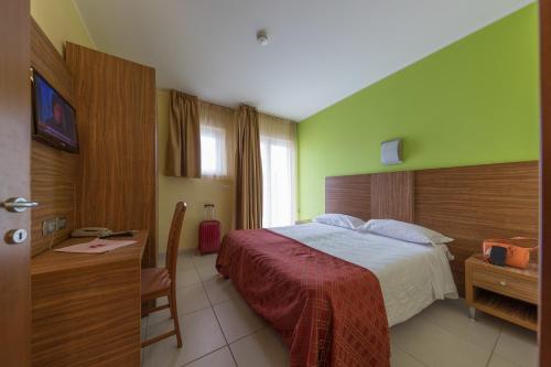 モンテジルヴァーノにあるホテル ラ ニンフェーアの緑の壁のベッドルーム1室
