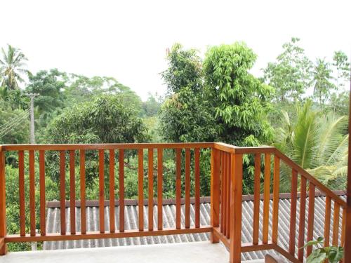 a wooden deck with trees in the background at lake paradise in Habaraduwa