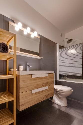 une salle de bain avec toilettes, lavabo et miroir dans l'établissement Annecy Jeremy Apartment, à Annecy