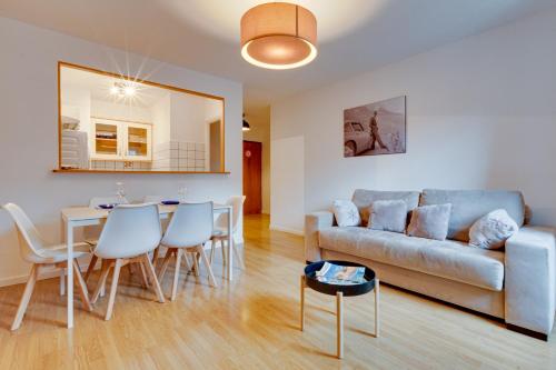 un salon avec un canapé, une table et des chaises dans l'établissement Annecy Jeremy Apartment, à Annecy