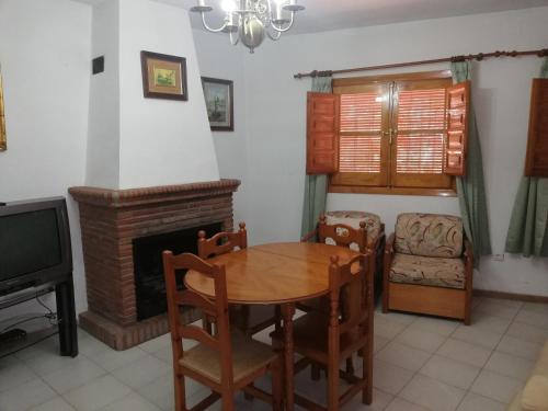 a dining room with a table and a fireplace at Apartamentos Cerro Negro - Los Magalites in Capileira