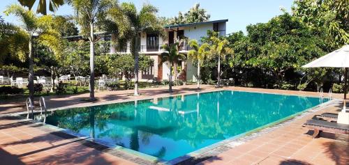 a swimming pool in front of a house at Gamodh Citadel Resort in Anuradhapura