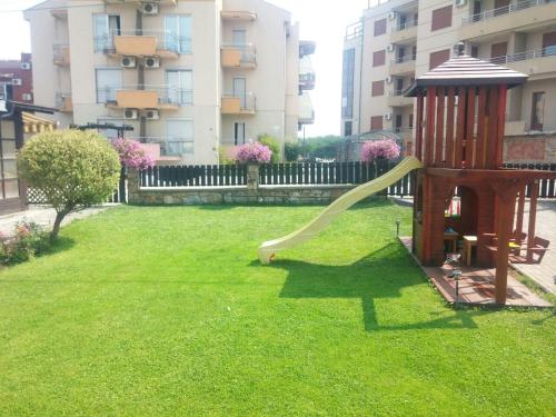 un parco giochi con uno scivolo in un cortile con un edificio di Apartmani Neca a Vrnjačka Banja