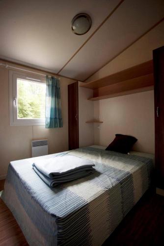 Un dormitorio con una cama con toallas. en Auberge de la Plage, en Baraize