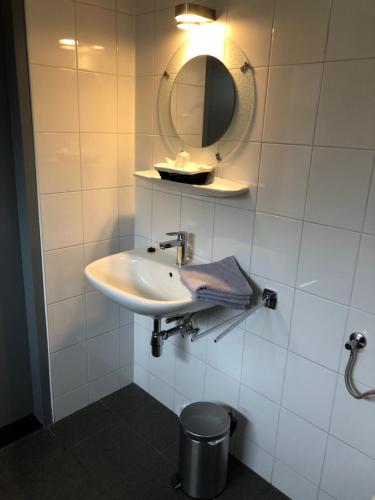 a bathroom with a sink and a mirror on the wall at Pension Brinkvis in De Koog
