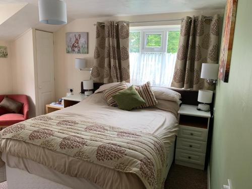 niewielka sypialnia z łóżkiem i oknem w obiekcie The Kings Head Inn w mieście Longhope