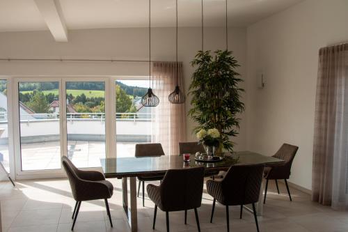 Penthouse Wäschenbeuren في Wäschenbeuren: غرفة طعام مع طاولة وكراسي