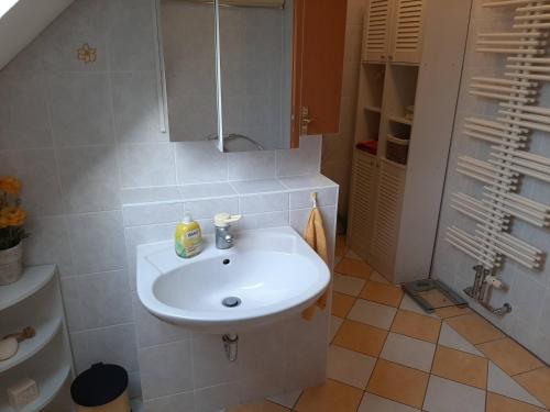 a bathroom with a white sink and a toilet at FeWo Hohen Neuendorf bei Berlin mit Sauna und Fuß-SPA in Hohen Neuendorf