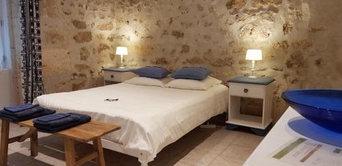 a bedroom with a bed with two tables and a sink at Les chambres de la grange in Cherval