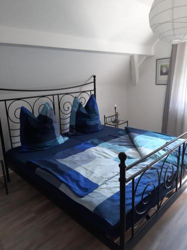 a bed with blue sheets and blue pillows on it at Ferienwohnung Bender in Gemünden