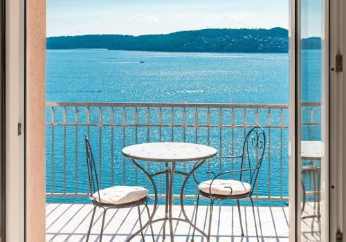d'une table et de chaises sur un balcon avec vue sur l'eau. dans l'établissement Apartments More, à Trogir