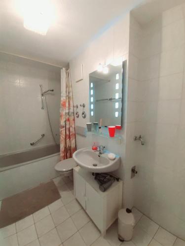 a white bathroom with a sink and a mirror at Wohnung im Herzen von Ettlingen in Ettlingen