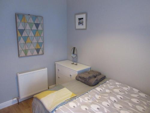 a small bedroom with a bed and a dresser at WEE NEUK in Cellardyke